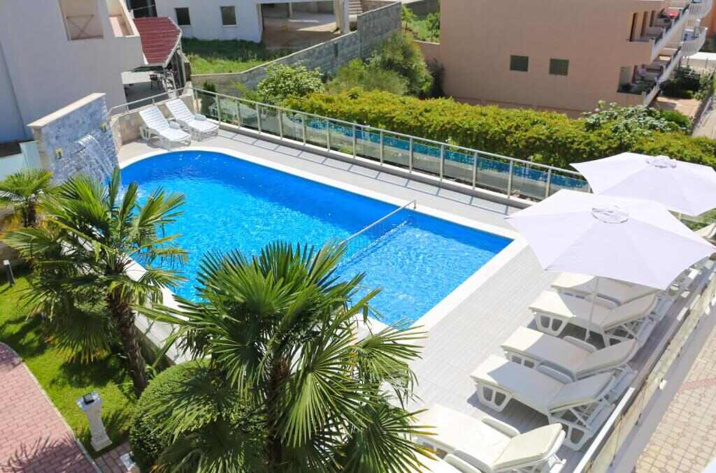 Outdoor swimming pool with sun loungers and palm trees